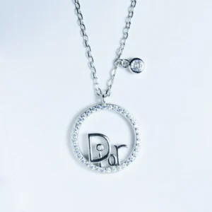 سلفر شكل دائرة مفرغه بداخلها كتابه " Dior " وبالسلسله دائره صغيره داخلها فص زيركون طول 50 سم